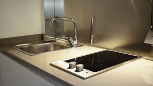 Eine Küche aus Edelstahl mit doppelter Spüle, integriertem Kochfeld und modernem Wasserhahn.