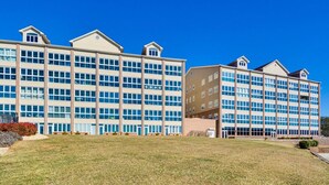 A multi-story hotel with a modern design, featuring a central courtyard and a flat roof. - Smith Mountain Lake Studio | Pool, Beach & Trails (Huddleston)