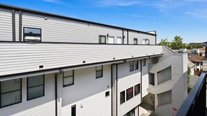 En flervåningsbyggnad med bostäder, ett platt tak och en balkong på översta våningen.