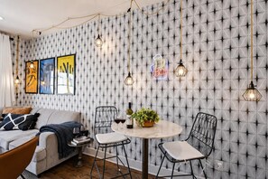 A room with a patterned wallpaper, a round table with chairs, a sofa, and hanging light fixtures. - Fall getaway near Belmont & Hillsboro Village, Nashville, sleeps 12 (Nashville)
