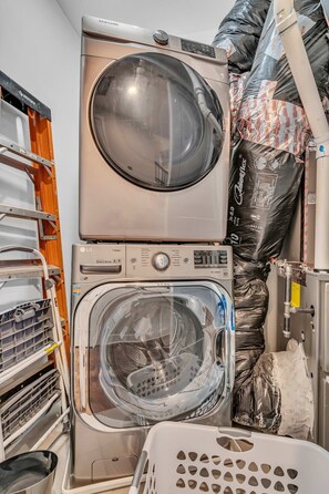 A stacked washer and dryer unit with a control panel, a transparent door, and a metal basket. - Nashville family townhome with rooftop deck & game room, sleeps 12 (Nashville)