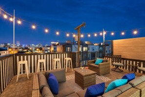 A rooftop terrace with outdoor seating, string lights, and a city view at dusk. - 4-bedroom Nashville townhome sleeps 12 near Centennial Park & Parthenon (Nashville)