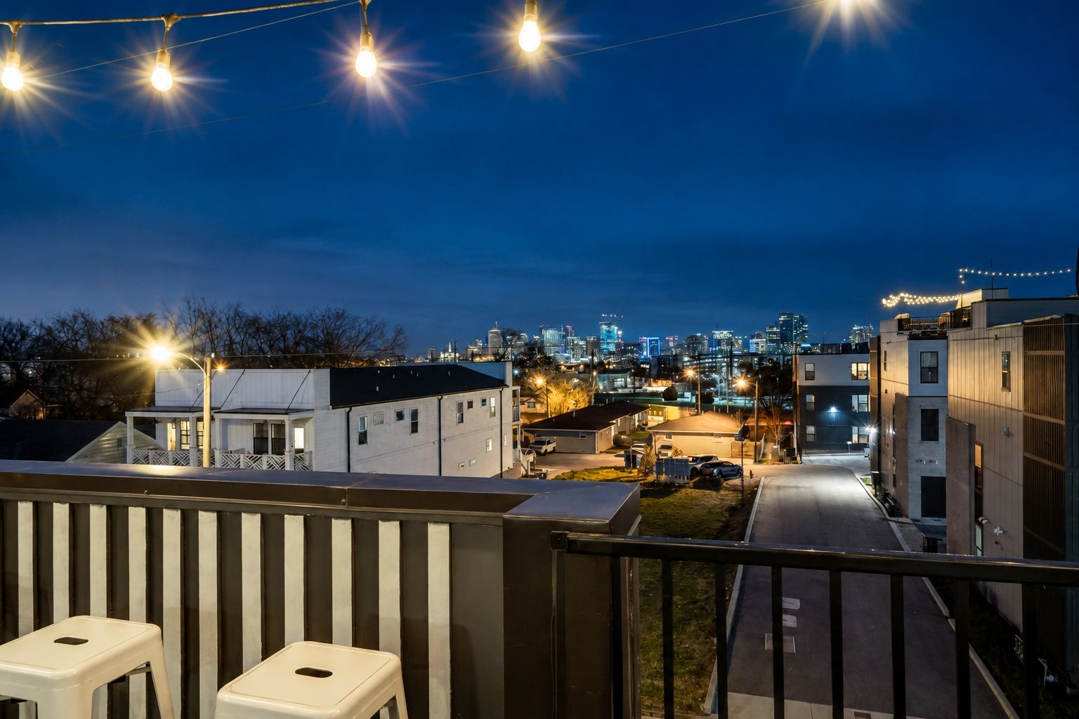 A residential area with a view of a city skyline at dusk.