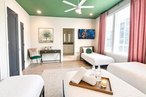 A hotel room with two beds, a desk, a chair, a painting, a television, and a window with curtains. - Fall in Nashville: Ping Pong Lounge house, sleeps 12, 4 baths (Nashville)