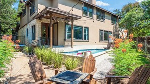 A two-story house with a patio area featuring outdoor furniture and a swimming pool. - ATX Oasis / Pool / Firepit / Billiards (Austin)