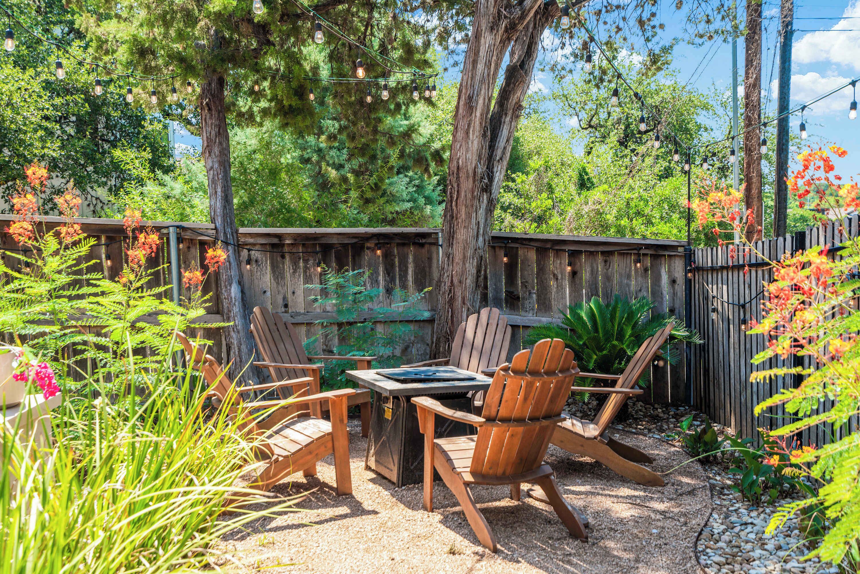An outdoor patio with wooden furniture, a table, and chairs.