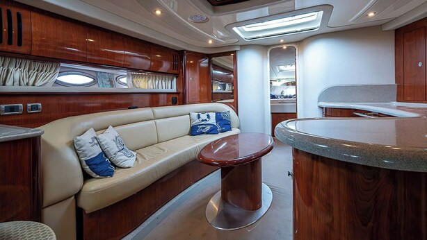 Ein luxuriöses Interieur mit einer Couch, einem runden Tisch und Holzschränken.