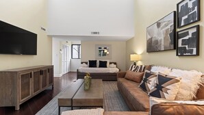 A modern living room with a sofa, coffee table, and TV. - Treetops 4904 by Avantstay Hilton Head Condo + Balcony + Shared Pool + Tennis Court + Near Beach and Dining (Hilton Head Island)