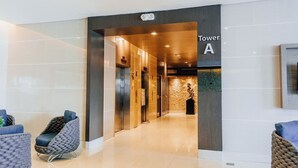 Een moderne hotelentree met een duidelijk bord waarop 'Toren A' staat.