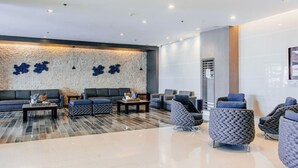 Een moderne lobby met een stenen muur, een zithoek en een groot raam.