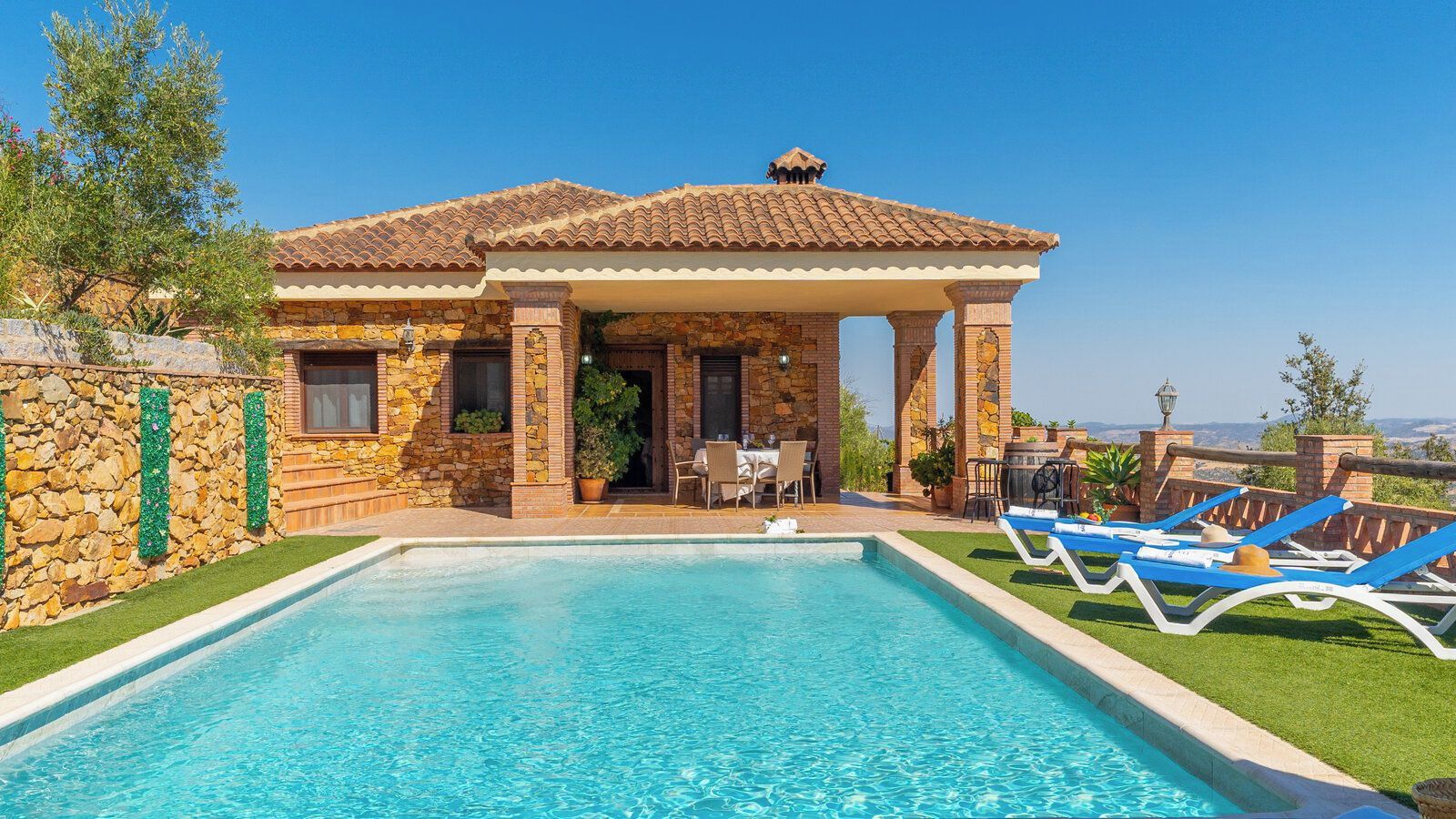 Une maison avec une piscine, un espace extérieur aménagé et une vue sur le paysage.