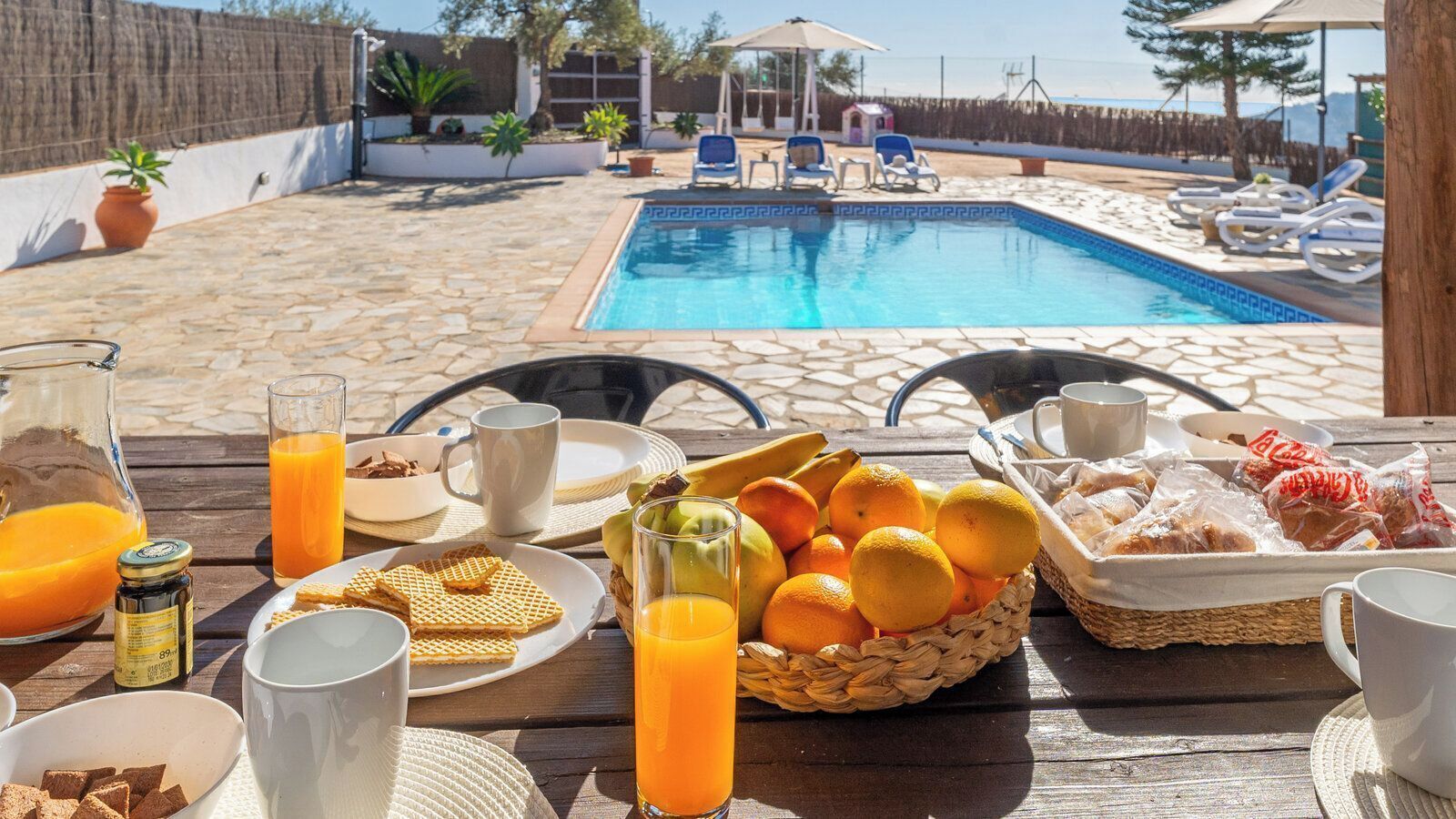 A breakfast setup with a pool in the background.