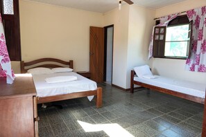 A bedroom with a wooden bed, a wooden bench, a nightstand, and a wardrobe. - Private paradise next to Guarajuba - Monte Gordo (Monte Gordo)