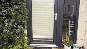 A black-framed door with a white shutter, a small step, and a metal doormat. - Comfortable unique space close to Warrenpoint  (Warrenpoint)