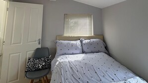 A bedroom with a bed, a chair, a window, and a door. - Comfortable unique space close to Warrenpoint  (Warrenpoint)