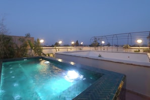 A swimming pool with a tiled edge, surrounded by a low wall and a pergola structure. - Riad Bab Sitiyn Hammam&Spa (Marrakech)