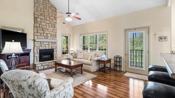A living room with a fireplace, a sofa, a coffee table, and a TV. - The Charming Retreat For 6! (Branson West)