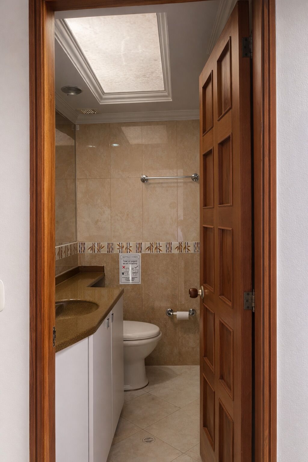 Une salle de bain équipée de toilettes, d’un lavabo et d’un porte-serviettes.