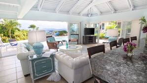 A spacious living area with a pool view, a television, and comfortable seating. - Yellowbird Villa, Pool, Ocean Views, 6 bed, Luxury (St. Thomas)