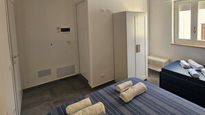 Una camera da letto con un letto, un armadio, uno specchio e una finestra.