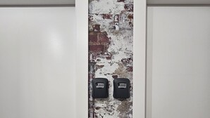 Una porta con una parete strutturata sullo sfondo, dotata di due dispositivi di comunicazione nera.