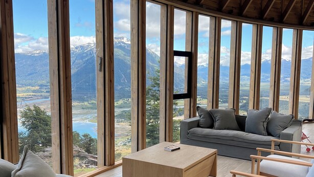 A spacious living area with a large window offering a mountain view.