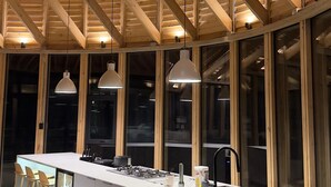 A modern kitchen with a central island, bar stools, and pendant lighting.