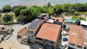 Zona residencial con edificios, paneles solares y una playa.