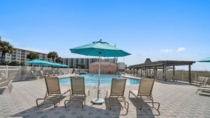 A poolside area with lounge chairs, umbrellas, and a pool. - Jetty East 106b (Destin)