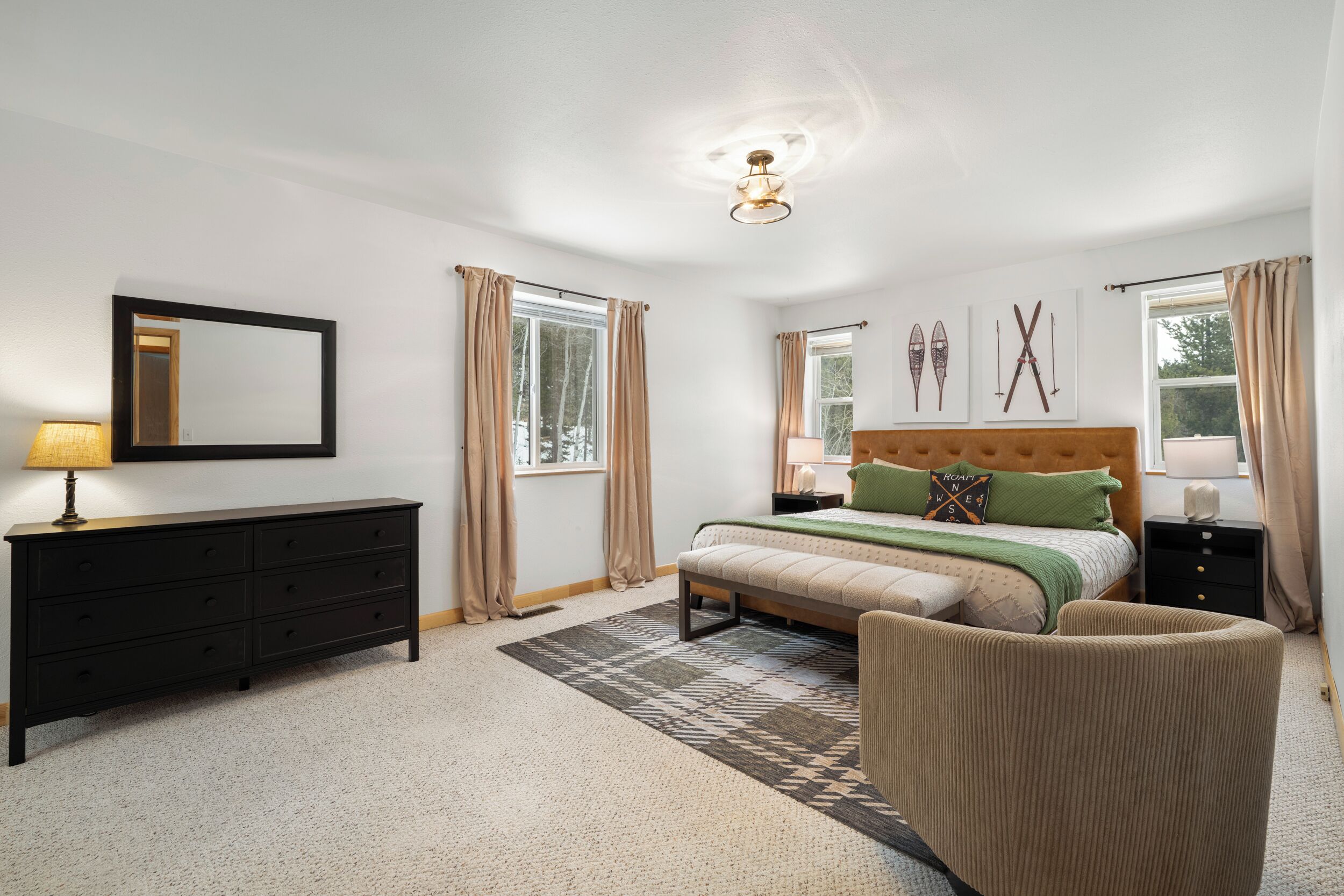 A bedroom with a bed, a dresser, a chair, and a nightstand.