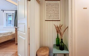 A room with a bed, a small table with vases, and a framed map on the wall. - Gorgeous home in Nykøbing Sj with WiFi (Nykøbing Sj)