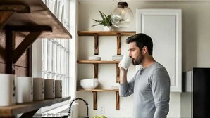 Une cuisine moderne avec des étagères en bois, une machine à café et un évier.