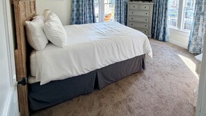 A bedroom with a bed, a ceiling fan, a dresser, and a TV. - Charming In-town Bungalow (Marianna)