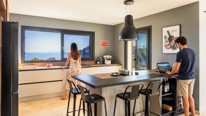 A modern kitchen with a large window, a bar area, and a dining space.