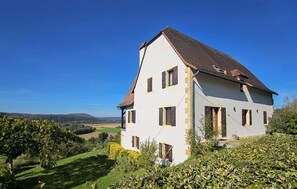 A two-story house with a sloped roof, multiple windows, and a garden in front. - Charmant avec vue paysagère (Castels et Bézenac)