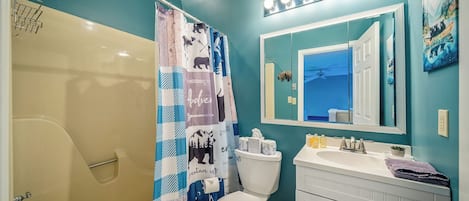 Un baño con ducha, inodoro, lavabo y tocador.