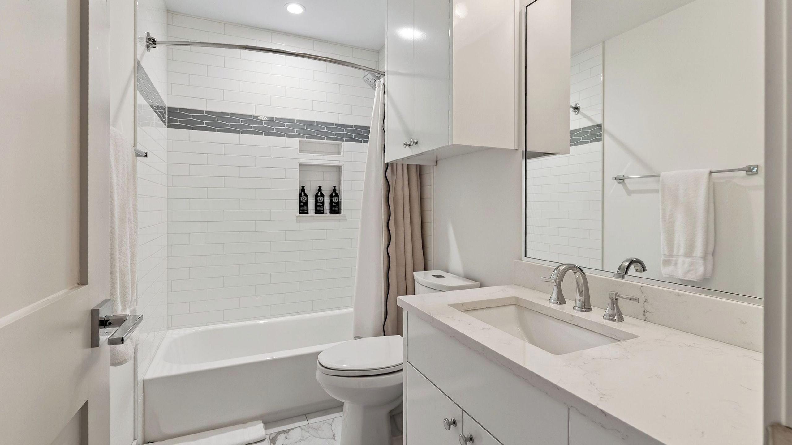 Een moderne badkamer met een bad, toilet en wastafel.