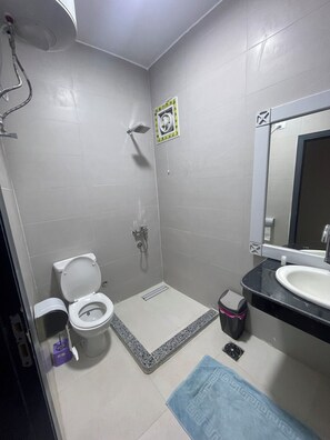 Een aparte badkuip en douche, handdoeken, zeep, shampoo