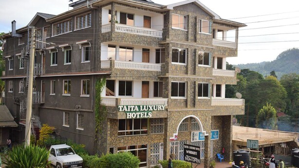 A multi-story building with a sign for Taita Luxury Hotels.