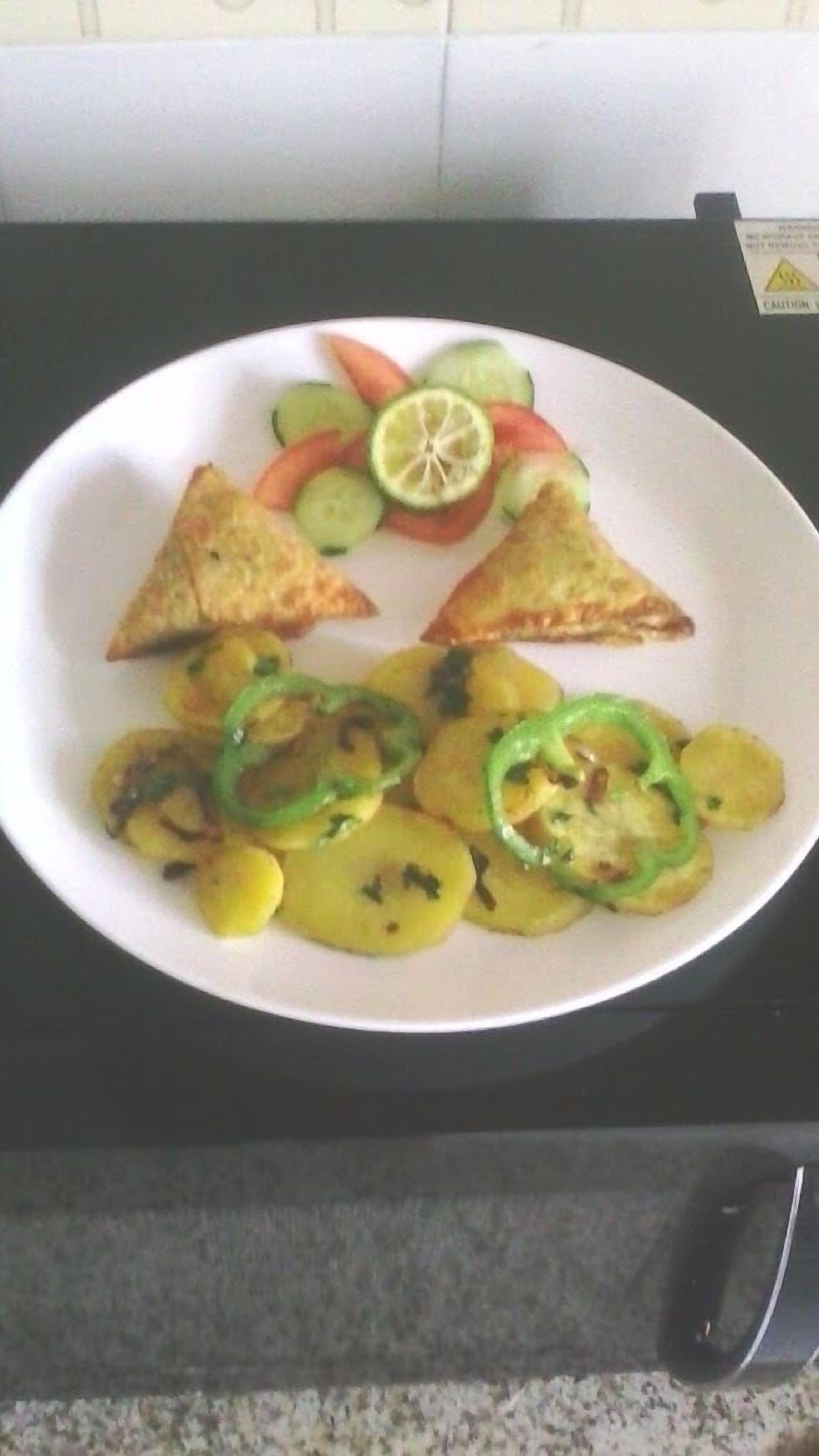 A plate with food items including sliced vegetables and triangular pieces of food.