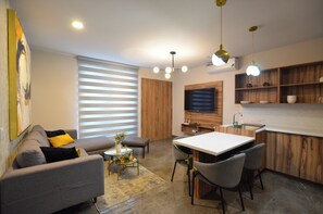 Suite, balcón, vista a la ciudad | Área de sala de estar