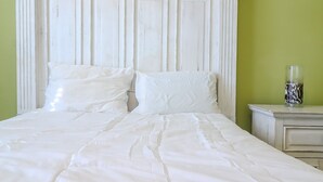 A bed with white bedding, a white headboard, and a bedside table with a glass vase. - Perfect Masters Week Stay- Spacious Home ONLY 10 Miles from Augusta National (North Augusta)