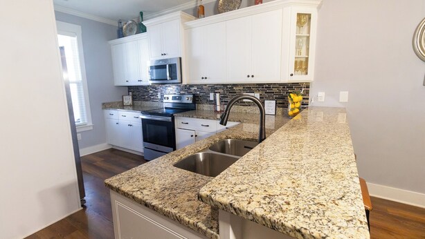 A kitchen with white cabinets, a granite countertop, stainless steel sink, and a microwave. - Perfect Masters Week Stay- Spacious Home ONLY 10 Miles from Augusta National (North Augusta)