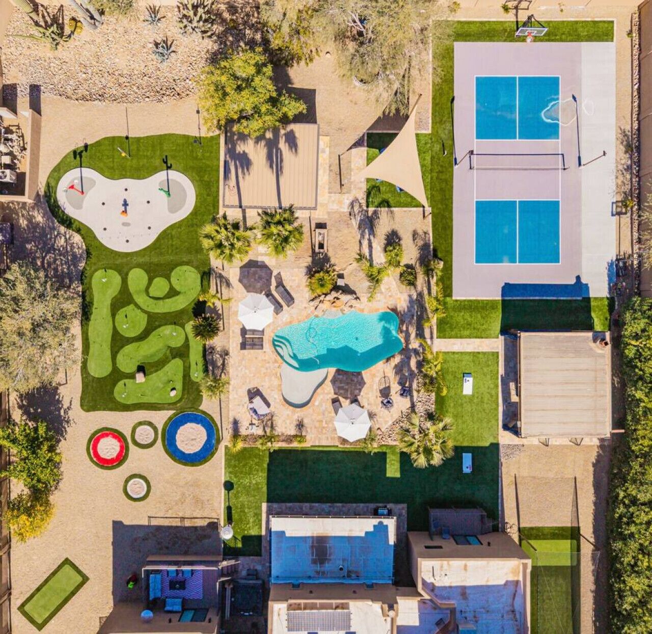 Vue aérienne d’une propriété dotée d’une piscine, d’un court de tennis et d’un terrain de golf.