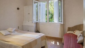 Una camera da letto con un letto, un armadio e una finestra con tende.