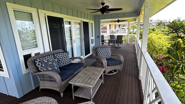 A covered porch with wicker furniture, a ceiling fan, and a view of the surrounding greenery. - Steps from the Beach! Exclusive 3/2.5 home in Poipu. Utilities Included! (Koloa)