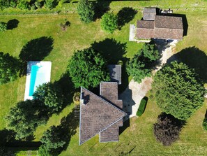 An aerial view of a property with a swimming pool, two buildings with sloped roofs, and surrounding greenery. - Le bois de saint-Cirq, private swimming pool (LE BUGUE)
