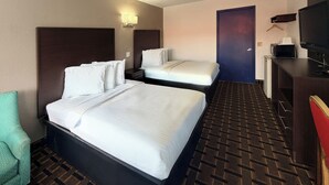 A hotel room with a large bed, a smaller bed, a desk with a TV, a microwave, and a chair. - Royal INN  (Richmond)