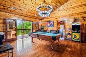 A wooden interior with a pool table, a Pac-Man arcade, and a view through a glass door. - 6 BR, large indoor pool, full arcade, views, cinema, and gameroom. Sleeps 25+ (Pittman Center)