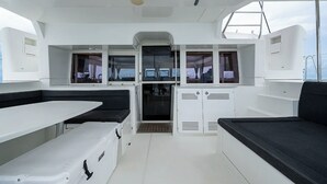 L'intérieur d'un bateau comprend un coin repas, des sièges et une petite cuisine.